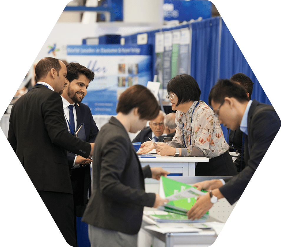 Attendees of a conference exchange information at a booth