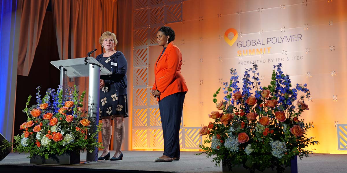 Two women speaking at the GPS conference at a podium.