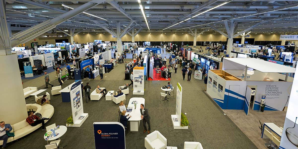 Overhead view of the conference room floor with vendors and participants throughout.